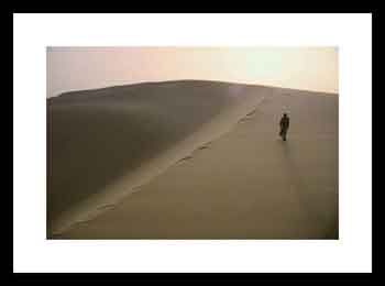 Arab walking on a large sand dune